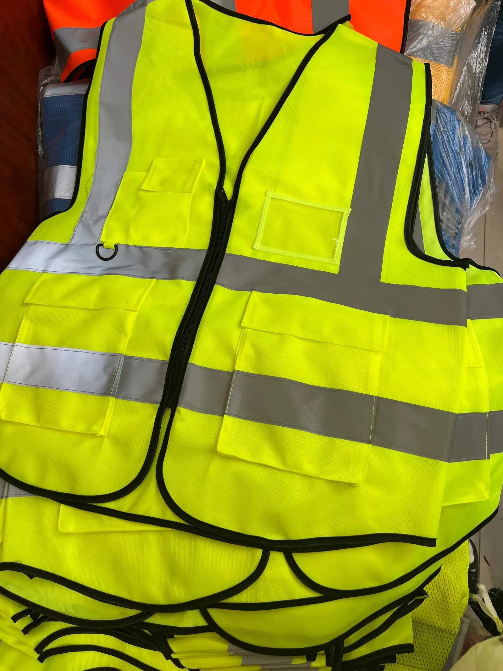 Finished fluorescent yellow reflective vest held for garment review