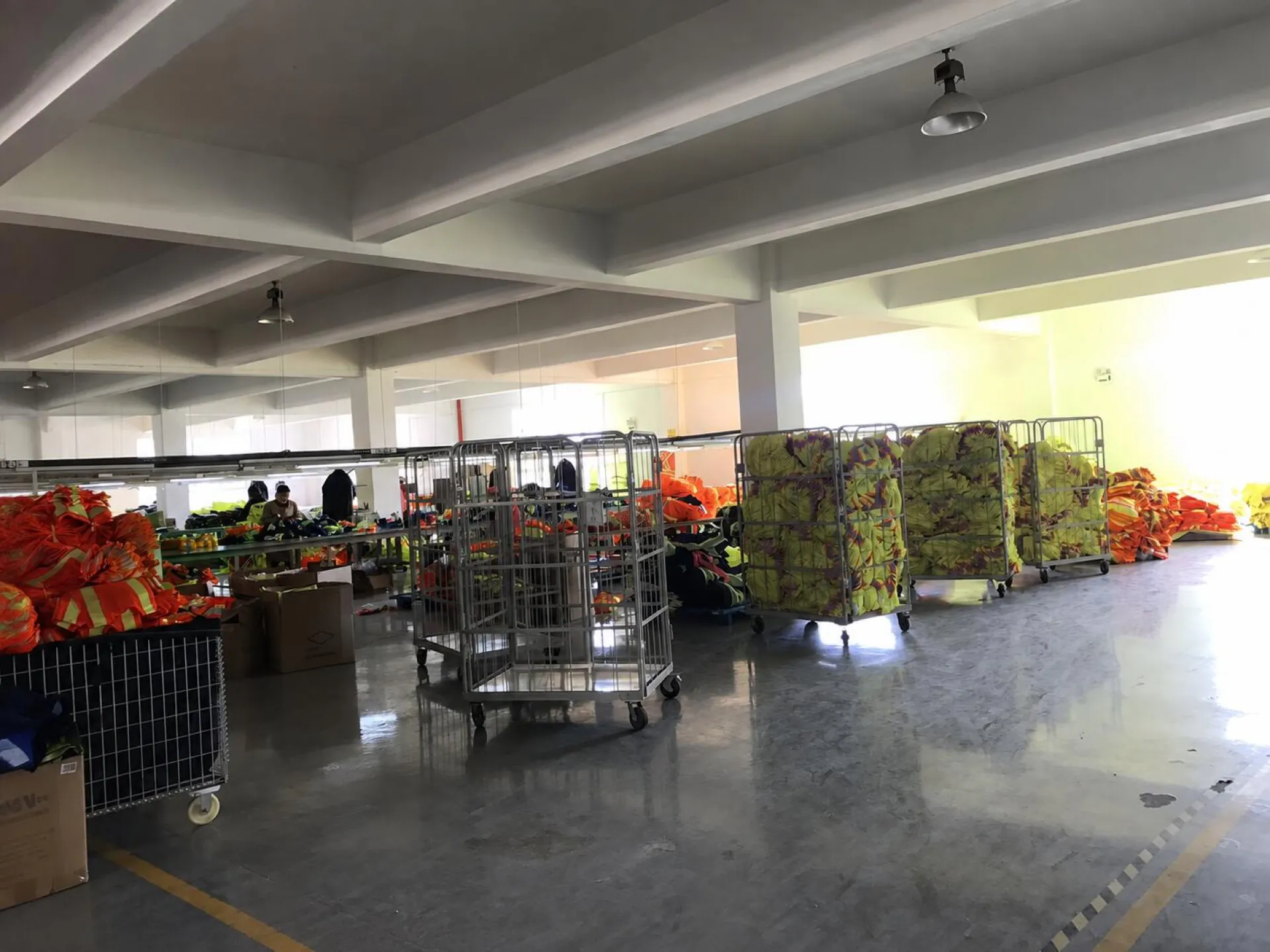 Fluorescent garments moving between work areas on a production floor